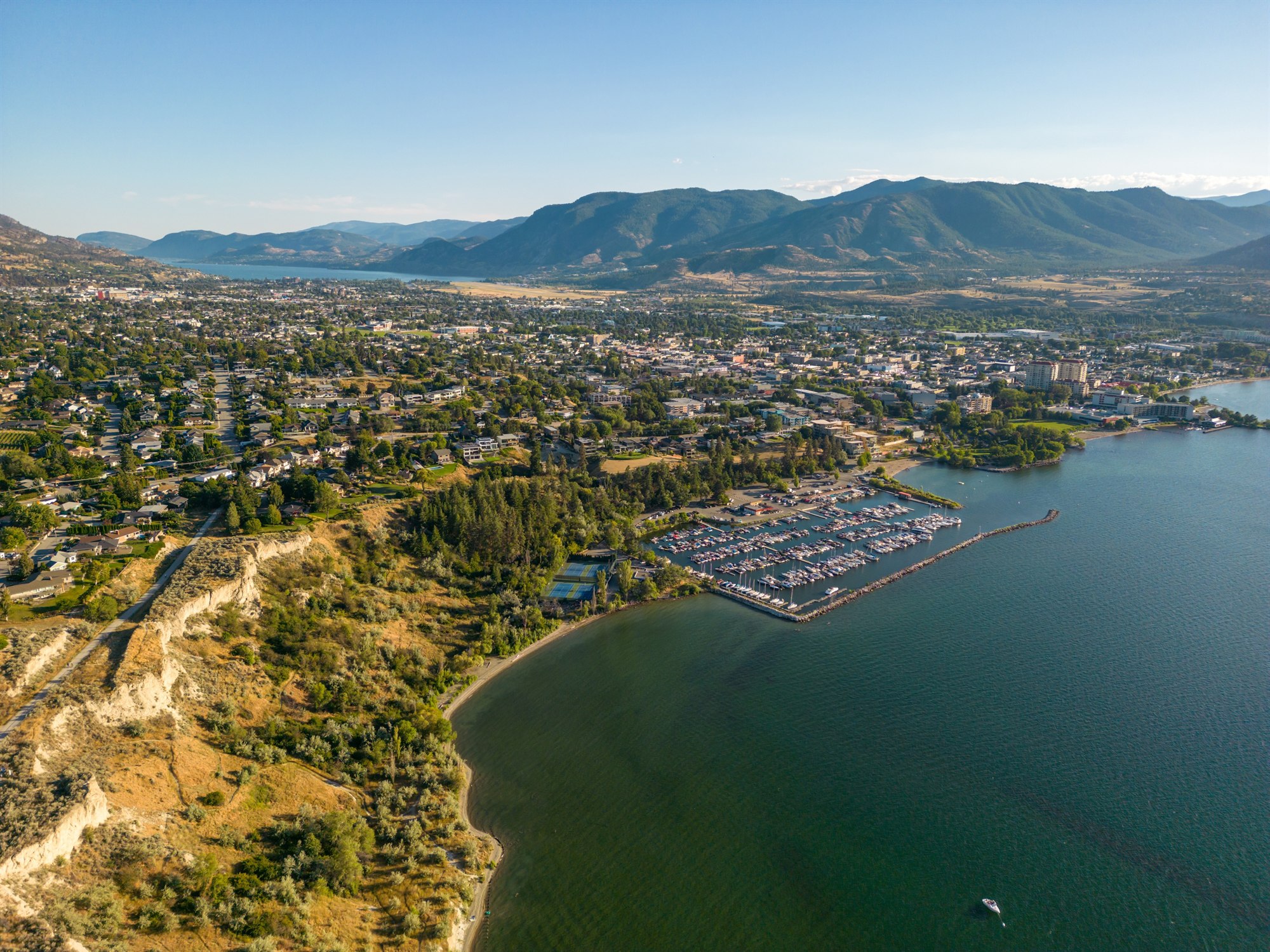 Aerial view of Penticton, its marina, lakeshore, and surrounding mountains